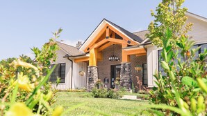 A modern house with a brick facade, a stone foundation, and a prominent wooden porch. - Overlook 7207 I Modern and Spacious 2Bd Apt (Knoxville)