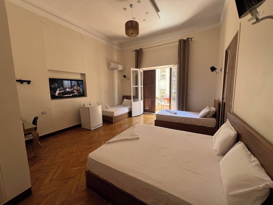 Habitación de hotel con una cama grande, televisión, escritorio y vistas al exterior.
