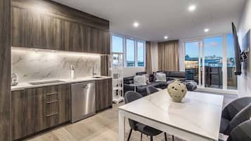 A modern kitchen with a marble backsplash, wooden cabinets, and a dining area with a white table and chairs.