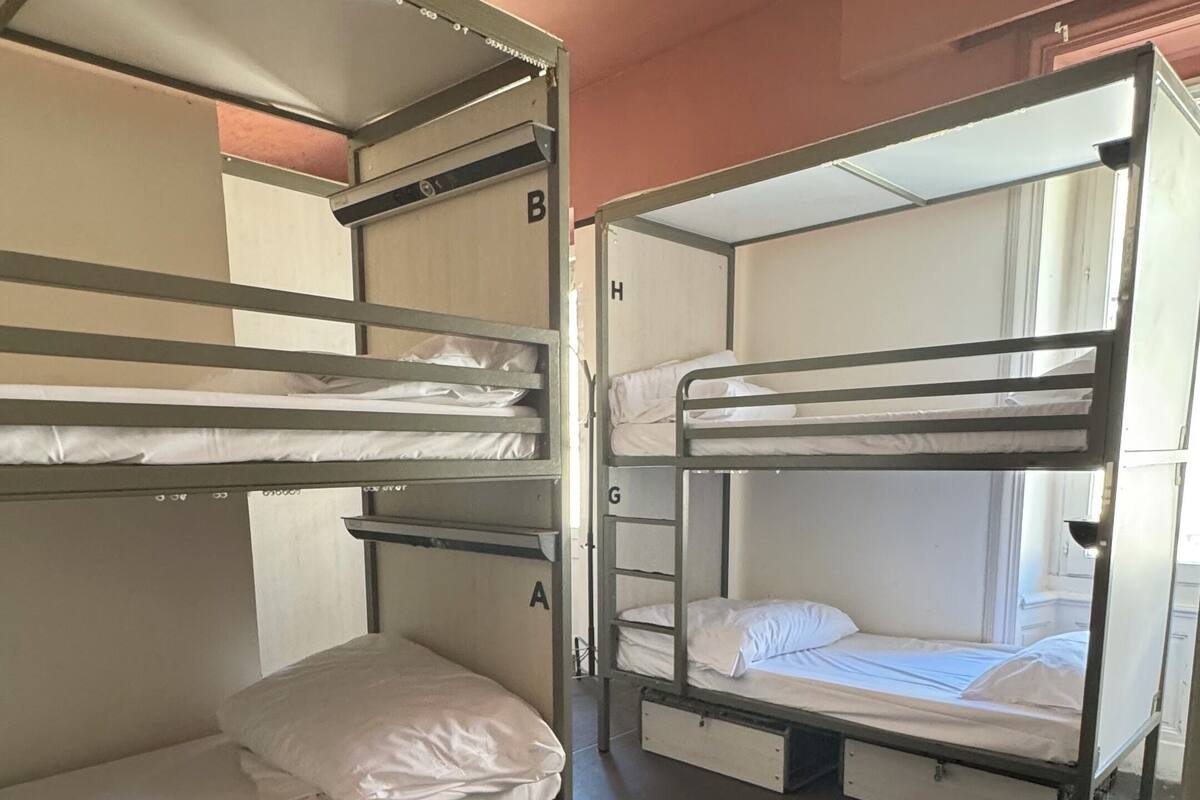 Een slaapzaal met stapelbedden, gelabeld A, B, G en H.