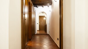 A hallway with wooden doors and a tiled floor. - Domus Lxvii Monti in Rome (Rome)