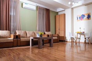En moderne stue med sofa, sofabord og spiseplads med stole og bord.