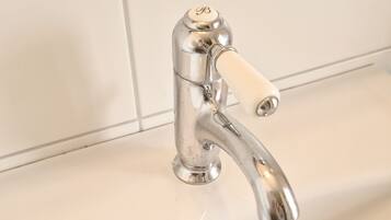 Un lavabo de salle de bain avec un robinet chromé et un drain.