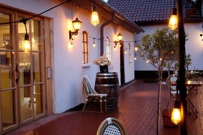 A cozy outdoor seating area with string lights, a wooden barrel, and a chair. - Fontänens Bed & Breakfast (Trelleborg)