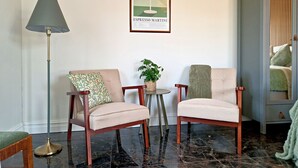 A room with two armchairs, a floor lamp, a small table with a plant, and a framed picture on the wall. - Fontänens Bed & Breakfast (Trelleborg)