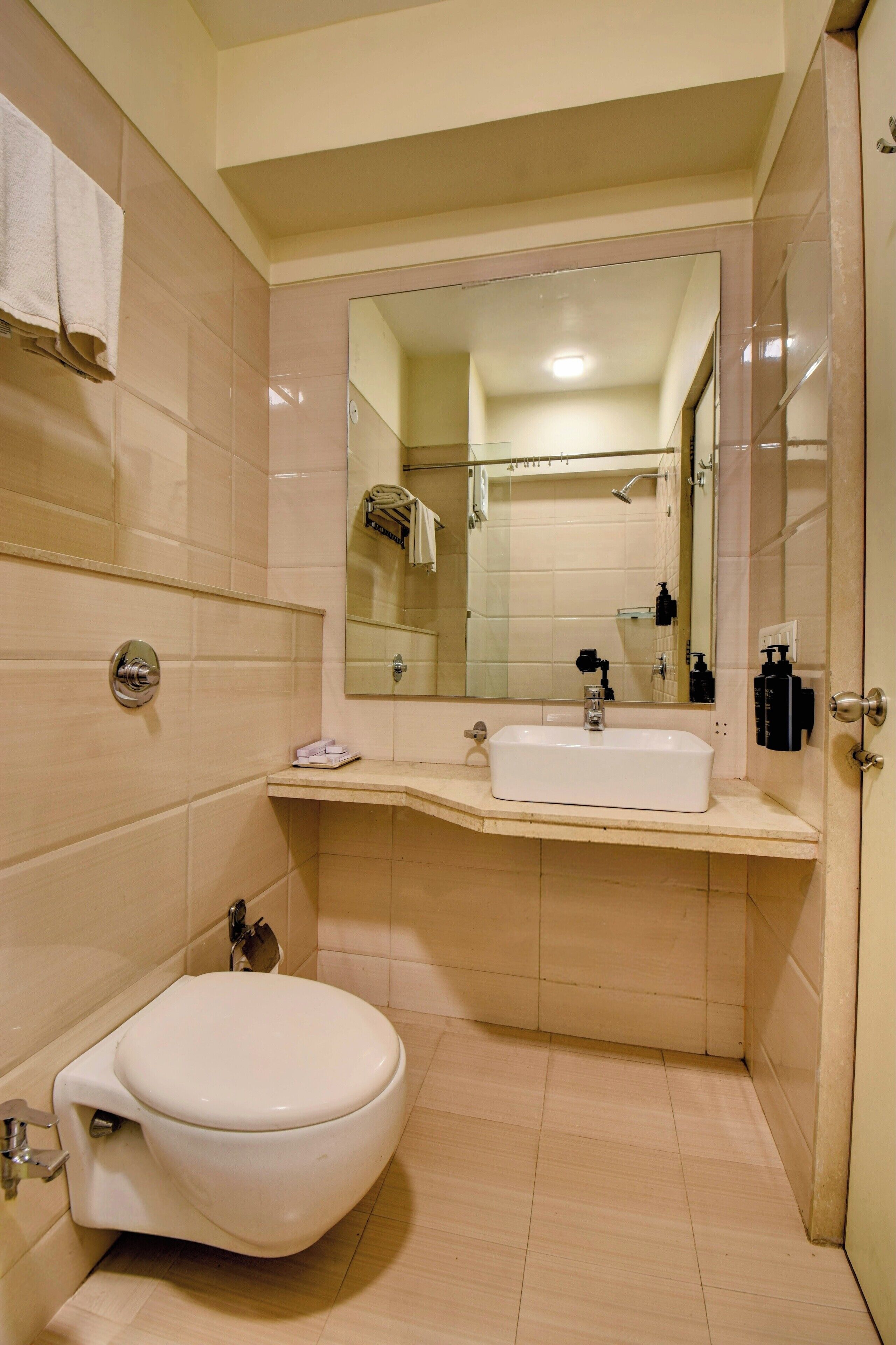 A compact bathroom with a white toilet, a sink, and a mirror.