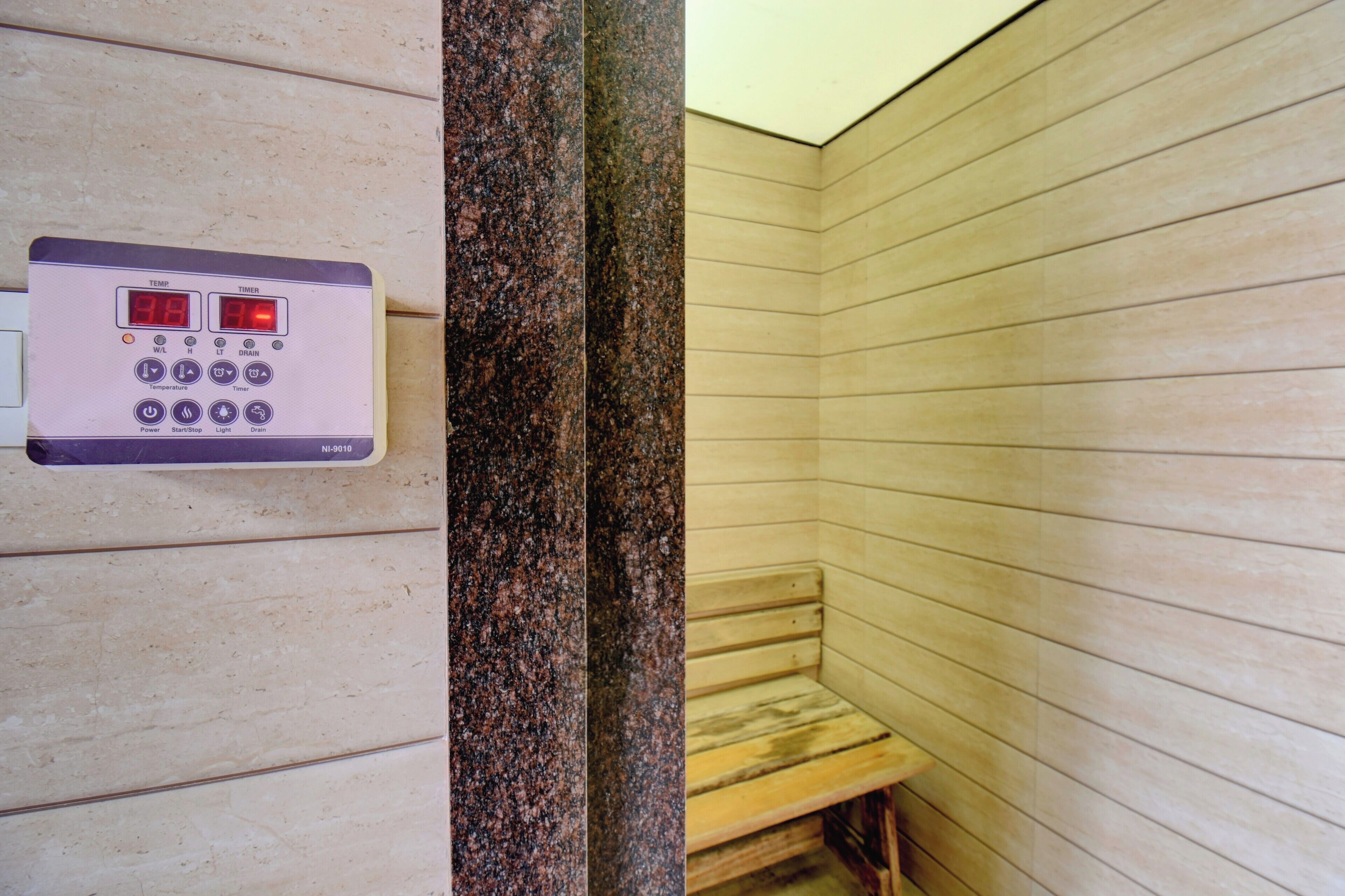 A sauna with a control panel and wooden benches.