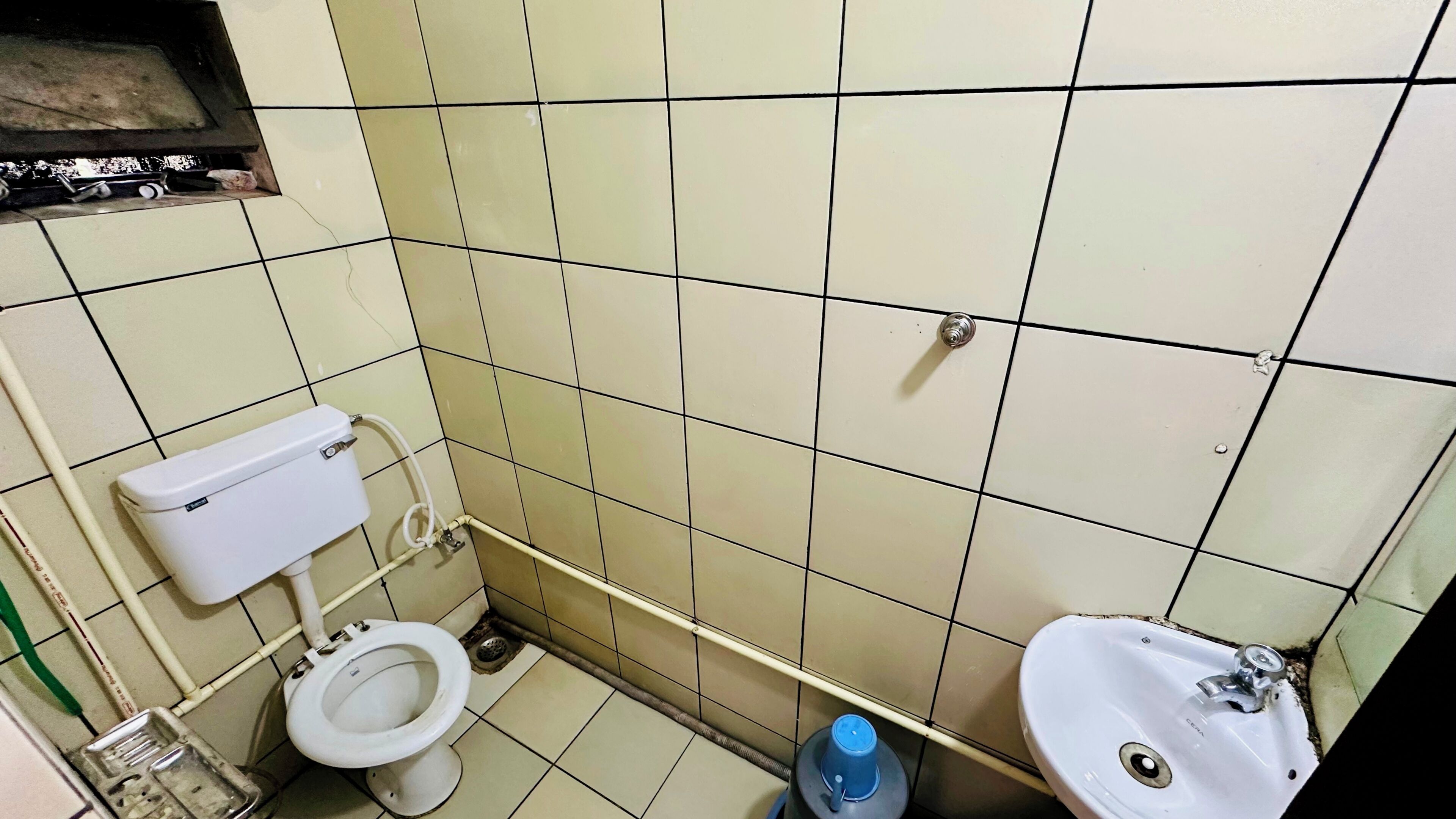 Un baño pequeño con inodoro, lavamanos y paredes de azulejos.
