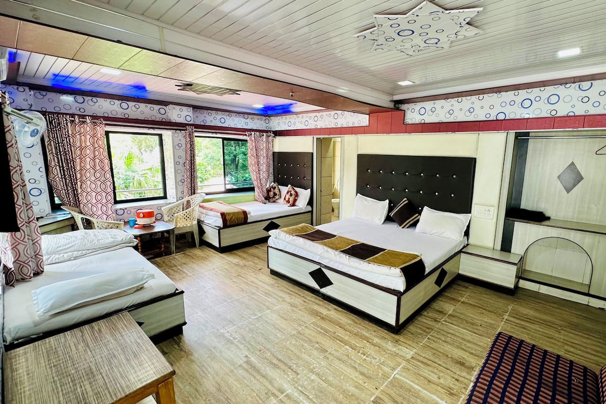A compact hotel room with two beds, a small desk, and a wardrobe.