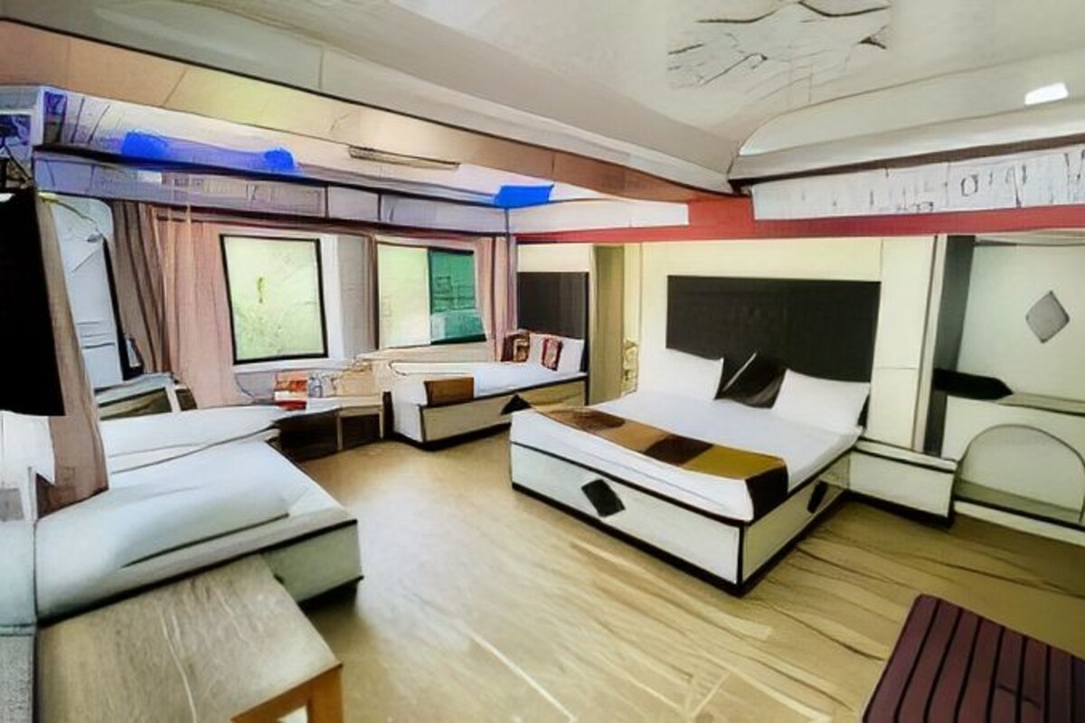 A modern hotel room with a large bed, a sofa, a desk, and a window.