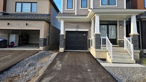 A residential building with a garage, a covered porch, and a driveway. - Amazing Home Niagara Fall .  (Thorold)