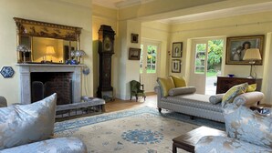 A traditional living room with a fireplace, patterned rug, and classic furniture. - Eclectic Dorset Country House, Hot Tub, Pool Table, Movie Room,12 guests & pets (Mapperton)