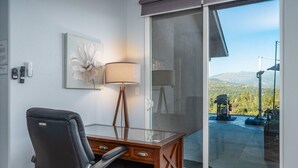 A room with a desk, chair, and a large window with a view of mountains and a landscape. - Hilltop Paradise with stunning views/hot tub/firepit/dog friendly! (Oakhurst)
