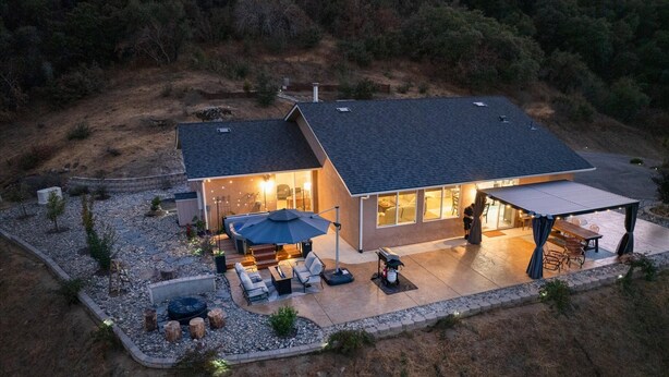 A modern house with a patio, outdoor seating, and a covered area. - Hilltop Paradise with stunning views/hot tub/firepit/dog friendly! (Oakhurst)