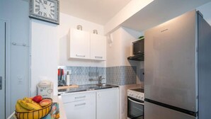 A modern kitchen with white cabinets, a stainless steel refrigerator, a microwave, and a sink. - Discover the Cocotier Athisien in Athis-Mons, a booming business located 20 minutes from Paris. (Athis-Mons)