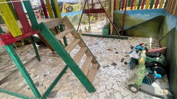 Una habitación con suelo de mosaico, un columpio y un patinete.