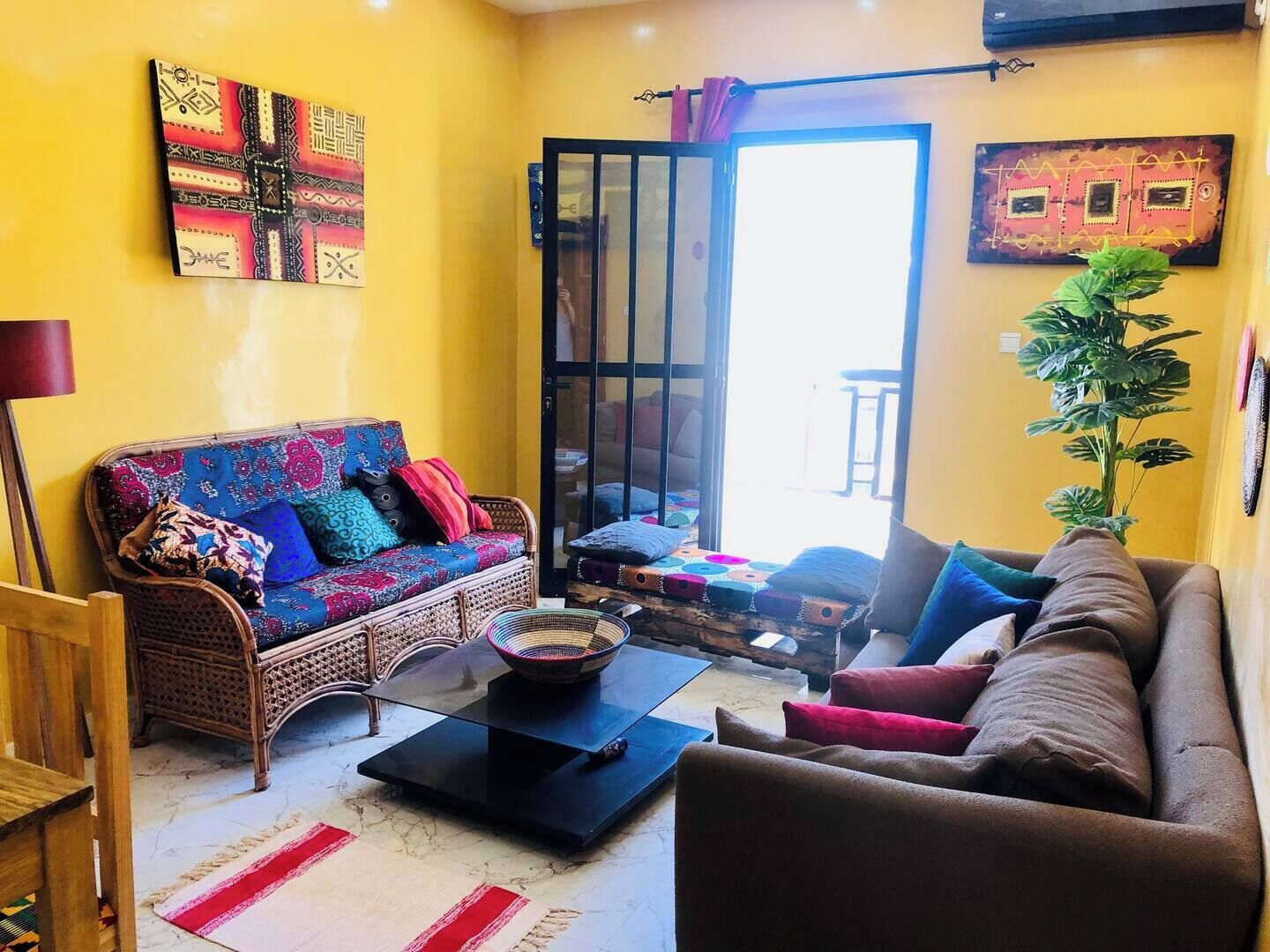 A living room with a sofa, a coffee table, and a plant.