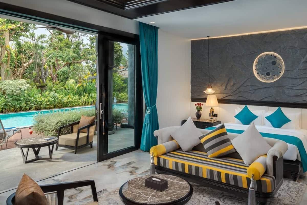 Un dormitorio moderno con una cama grande, vista a una piscina y una pared de piedra con diseño de luna.