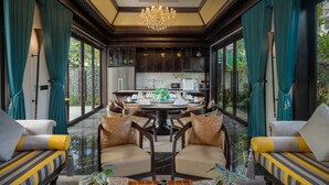 A dining area with a round table, chairs, and a chandelier.