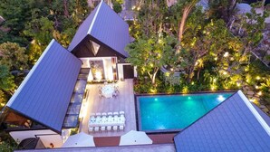 A modern house with a swimming pool, outdoor seating, and a well-maintained garden.