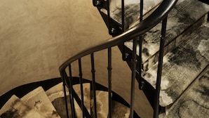 A spiral staircase with a handrail and steps.