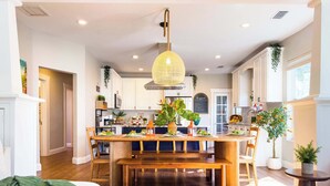 Una cocina luminosa con encimeras de madera, una isla central con asientos e iluminación colgante.