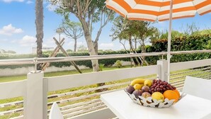 A table with a fruit basket on an outdoor terrace with a view of a lake and trees. - Comfortable Flat 350mt From the sea (Lignano Sabbiadoro)