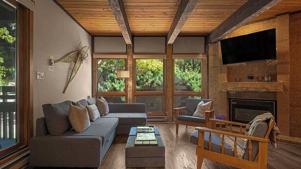 A modern living room with a sectional sofa, a wooden coffee table, and a fireplace.
