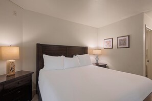 A hotel room with a large bed, two bedside tables with lamps, and two framed pictures on the wall. - Alpine Retreat Lodge (Steamboat Springs)