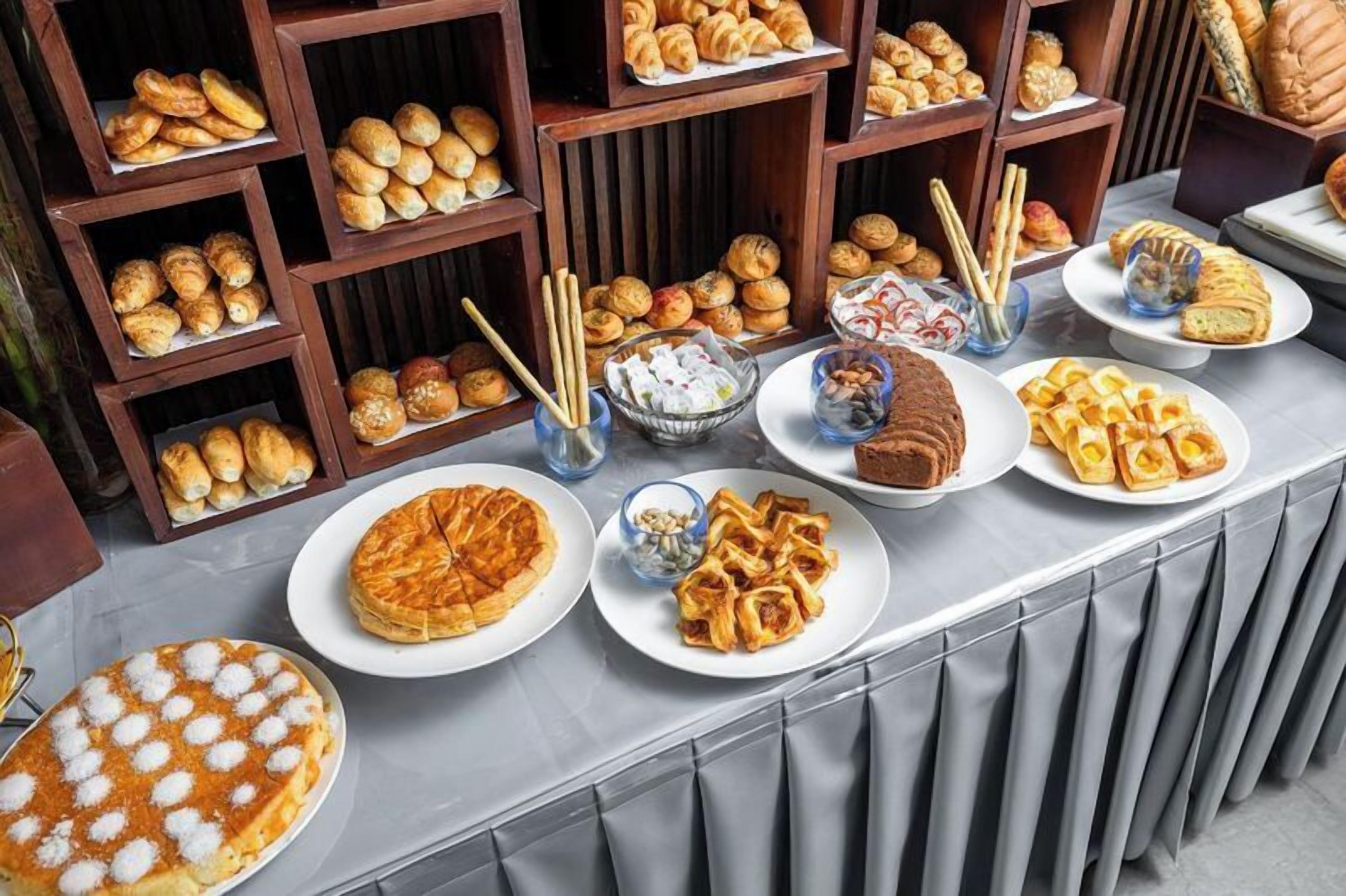 A buffet table with various baked goods and pastries.