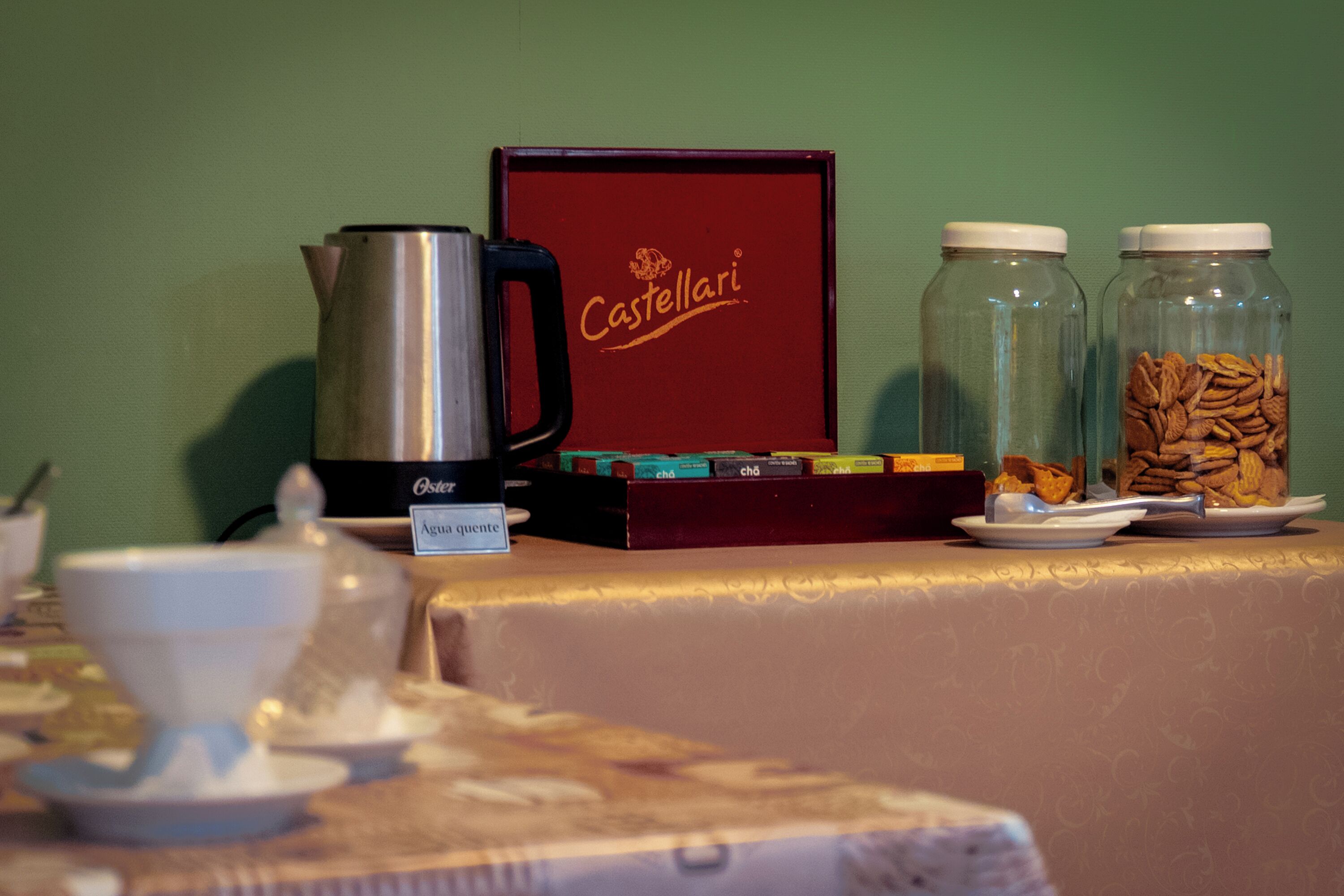 A table with a coffee maker, jars of nuts, and a box labeled "Castellari."