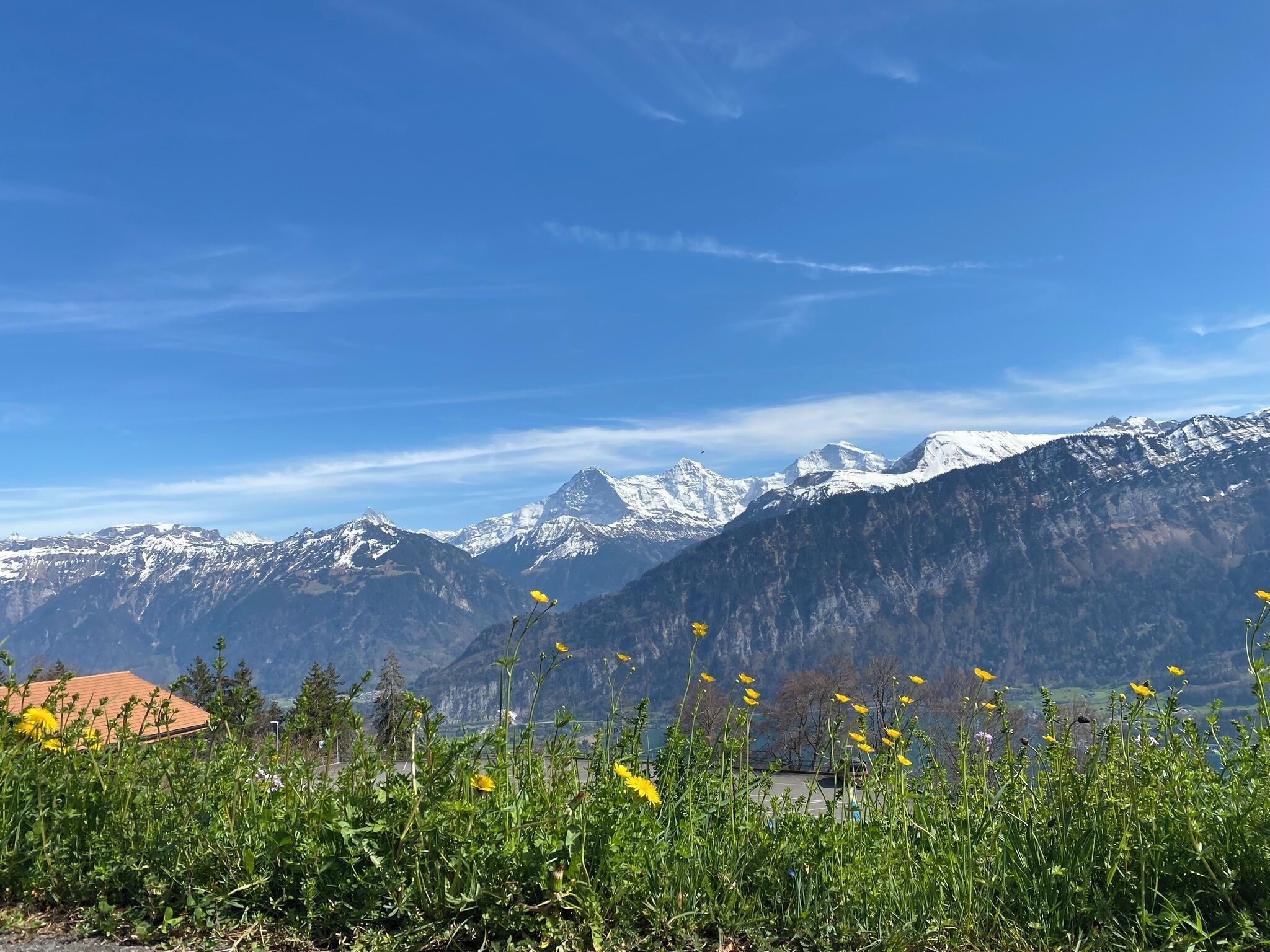 A mountain landscape with snow-capped peaks and a clear blue sky.