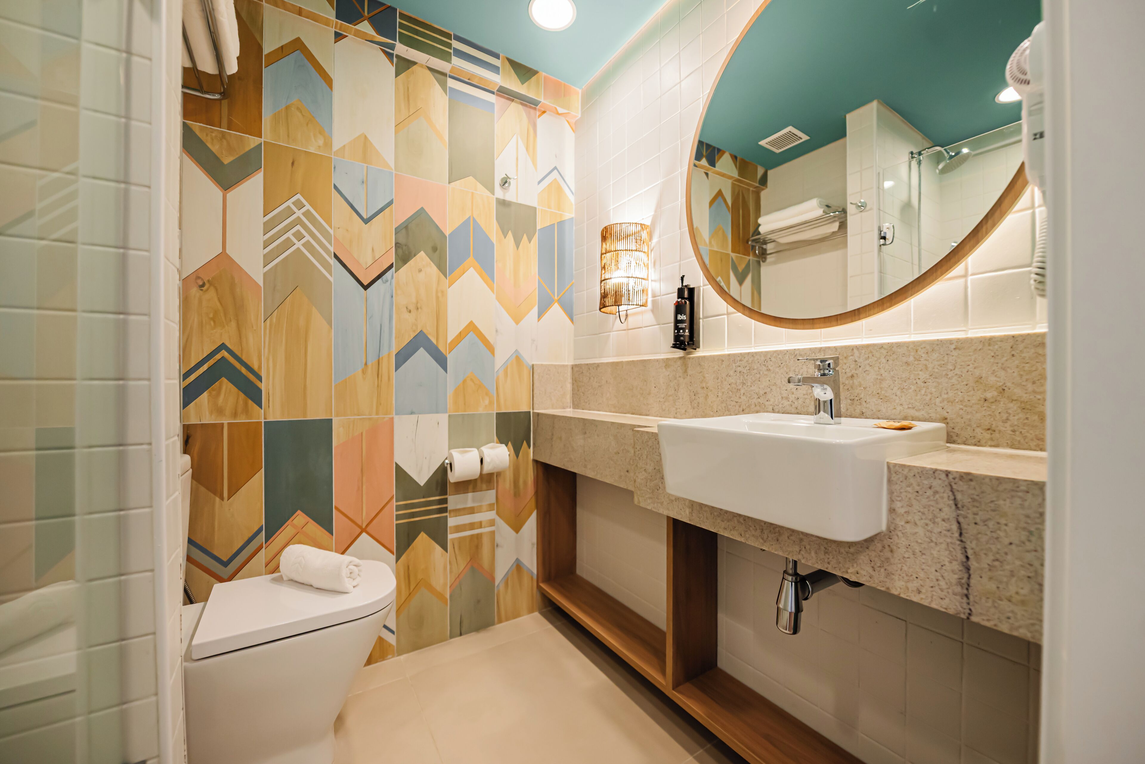 Un baño con inodoro, lavamanos y espejo.