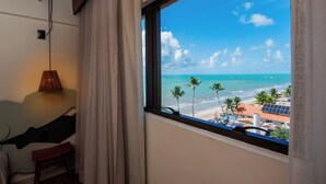 A room with a view of the beach, a lamp, and a chair. - Ibis Styles Maragogi (Maragogi)