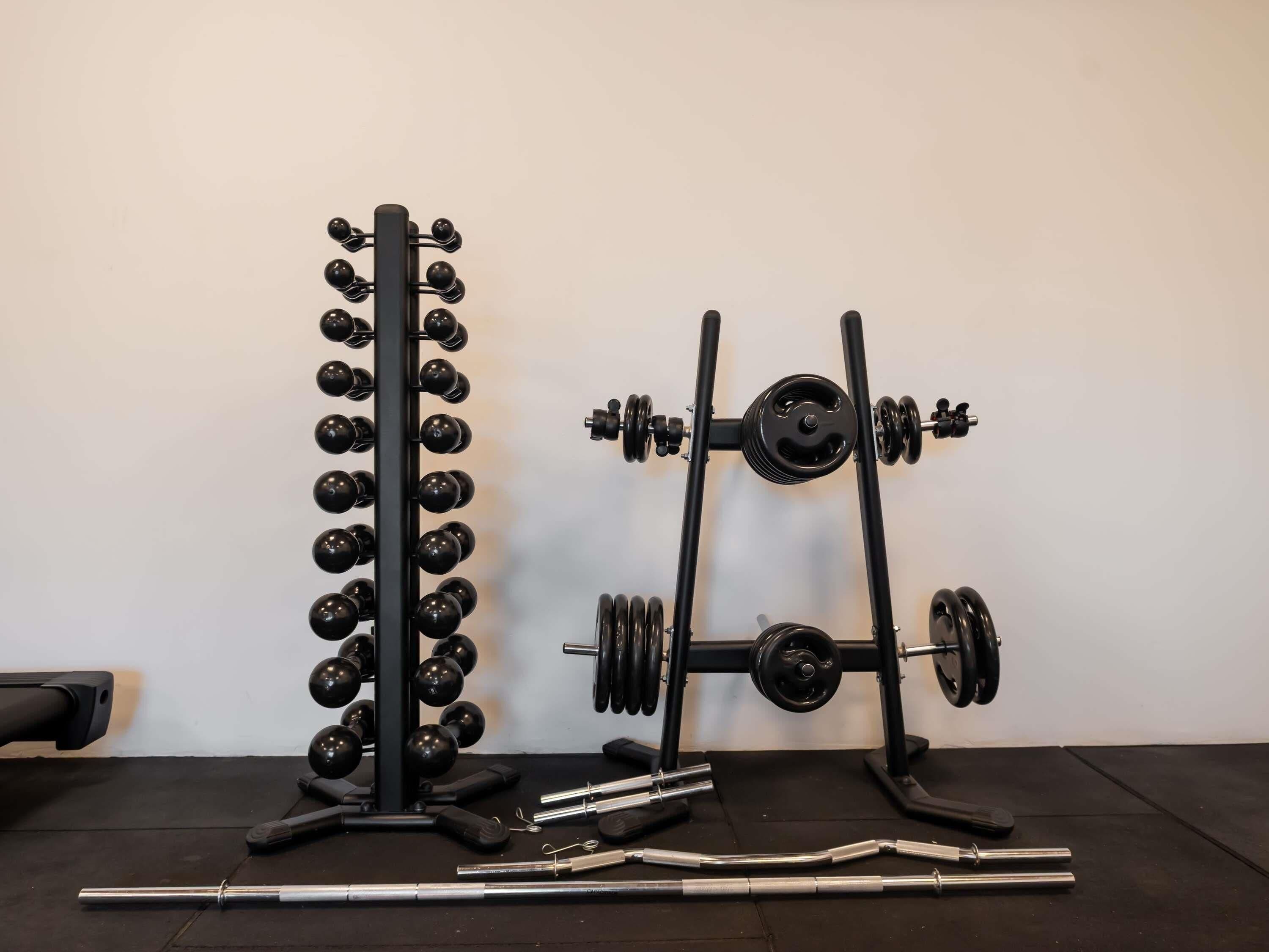 Un gimnàs amb equipament d'halterofília, incloent una barra per a squats i un aparall de pressa de banca.