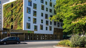 A modern hotel with a white facade, large windows, and a green vertical garden. - ibis Styles Paris Porte de Pantin Philharmonie (Pantin)