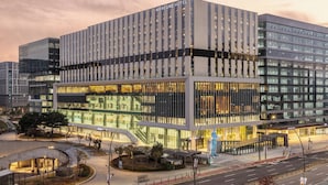 Un hôtel moderne doté d’une façade en verre, de plusieurs étages et d’une entrée imposante.