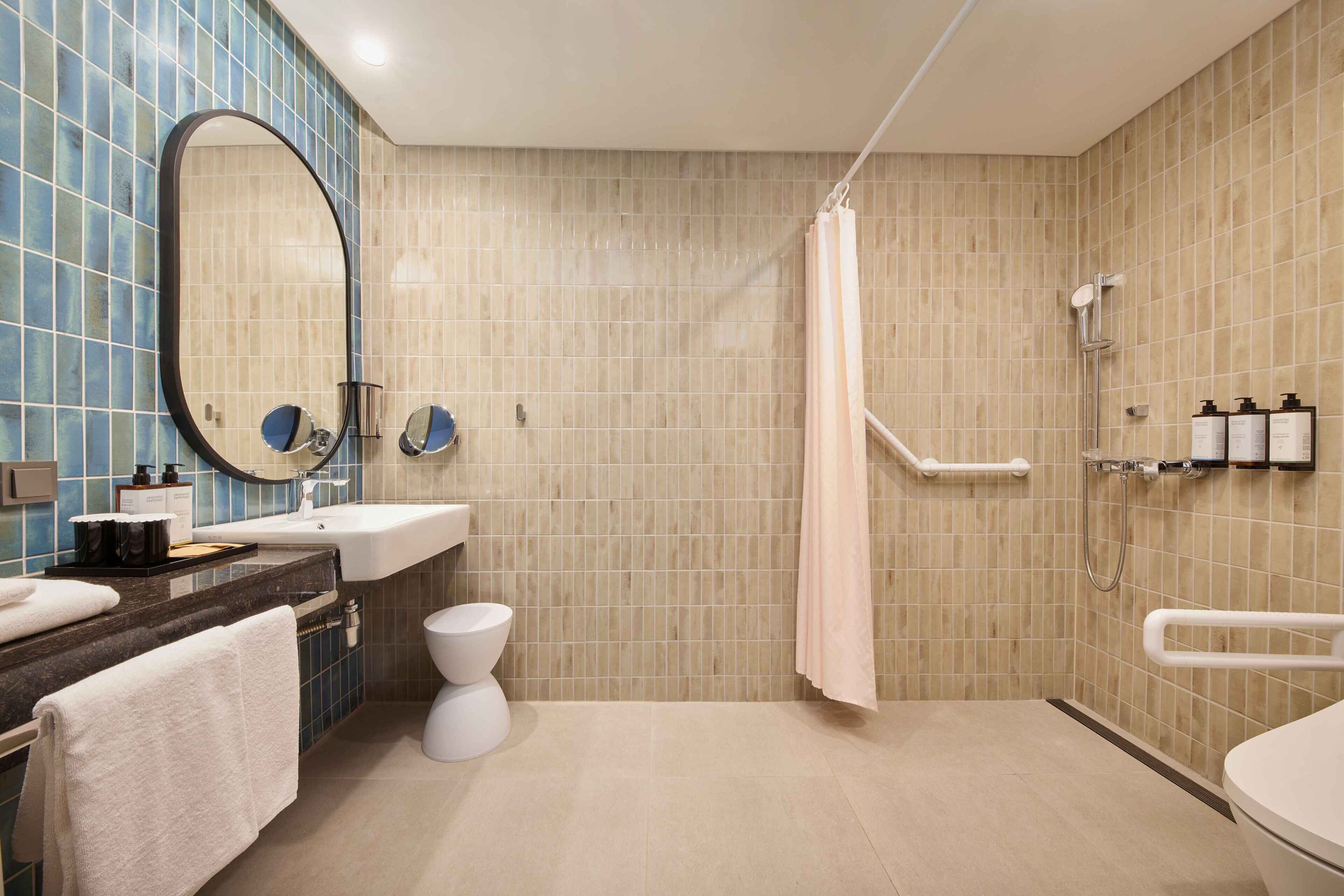 A modern bathroom with a shower, toilet, and sink.