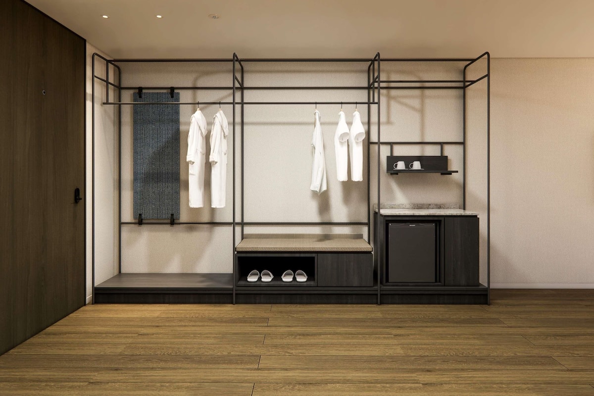 A modern room with a built-in wardrobe, a bench, and a small cabinet.