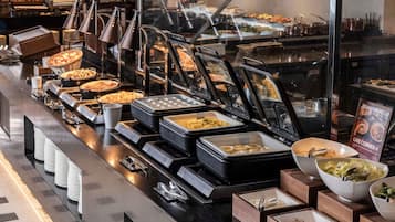 Un bufé con varias estaciones de comida, incluyendo una zona en vivo para cocina asiática.