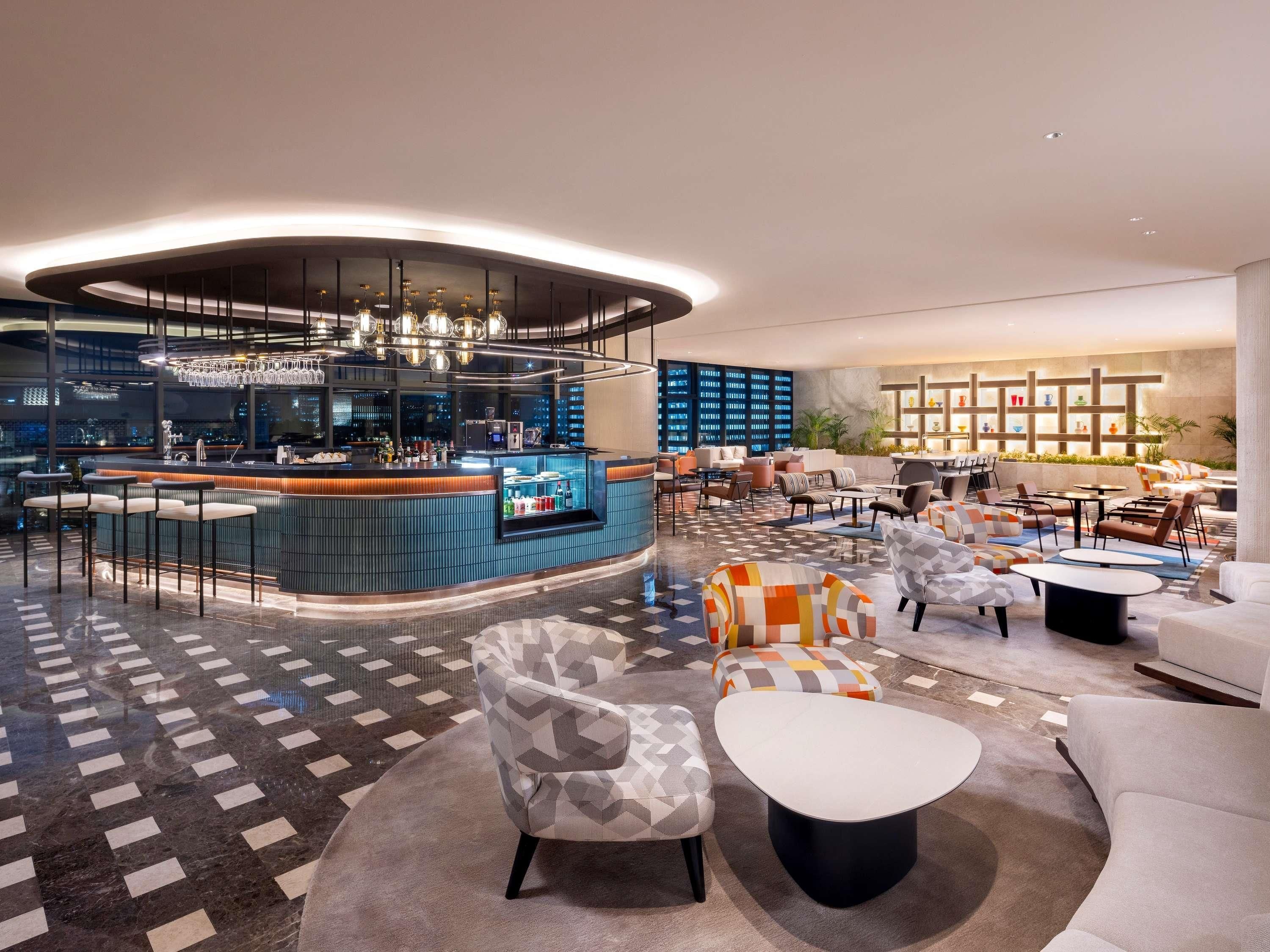 Un área de descanso moderna con bar, asientos y vistas a la ciudad.