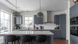 A modern kitchen with a large island, dark cabinets, and pendant lighting. - Amazing ski in/ski out Chalet in Åre - Övre Sadelvägen Ski Lodge   (Jämtlands län)