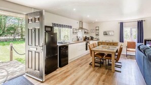 Una cocina moderna con comedor, horno empotrado y un amplio ventanal.