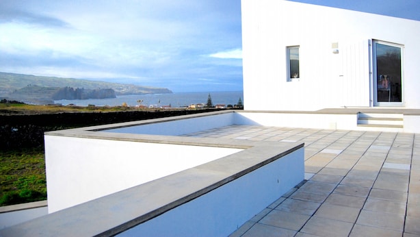 Un edificio moderno con piscina y vistas al mar.