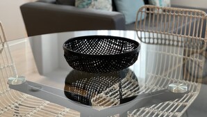 Une table en verre transparent avec un panier tressé au centre.