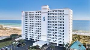 Un hôtel de grande hauteur, doté d’un logo bien visible, d’un parking et offrant une vue sur la plage.