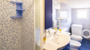 A bathroom with a tiled shower, a sink with a mirror, a toilet, and a blue shelf. - Relax in Loano With Terrace by Wonderful Italy (Loano)