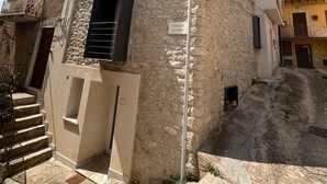 A stone building with a sign reading "DISCESA DUOMO". - Le Camere dell'Emiro 2 (Castronuovo di Sicilia)