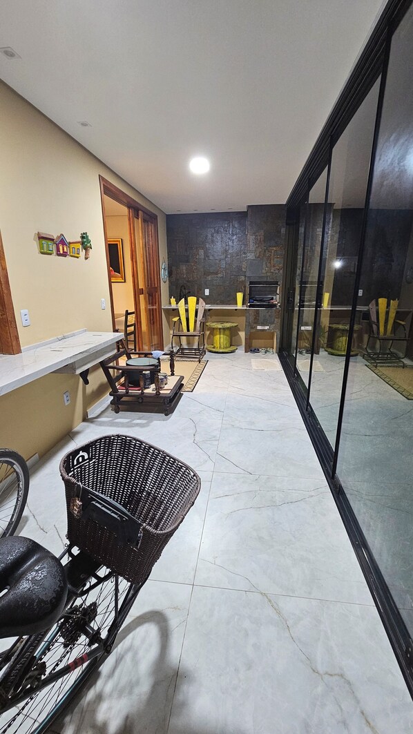 A spacious balcony with a dining area, a wicker chair, and a bicycle.
