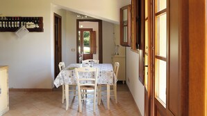 A dining area with a table set for four, wooden chairs, and a wall-mounted wine rack.